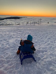 Kind auf Schlitten auf dem Belchen.