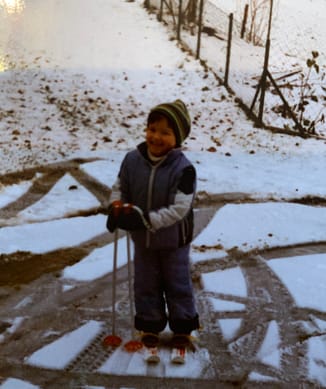 Kleines Mädchen steht auf Skiern.