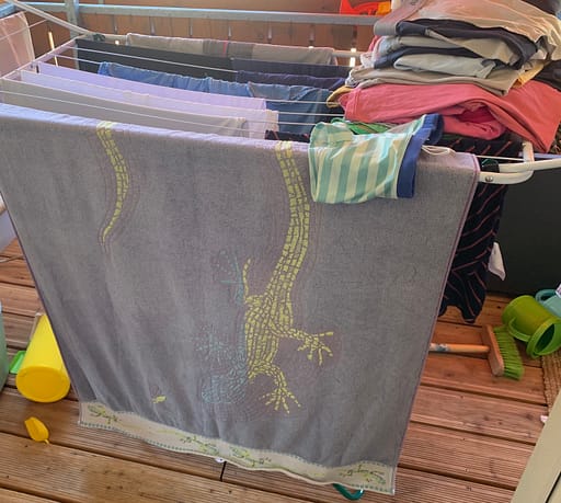 Wäscheständer mit Wäsche behängt auf dem Balkon stehend.