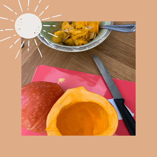 Aufgeschnittener Kürbis auf einem Schneidebrett liegend.